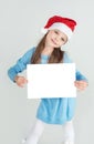 ÃÂ¡ute girl in Santa Claus hat with a white blank paper sheet. ÃÂ¡